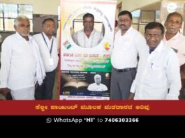 A group of people taking a selfie in front of a banner promoting the Karnataka assembly elections.