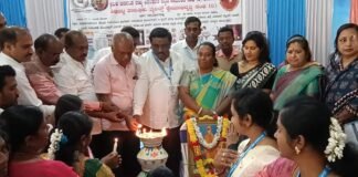 CMC Commissioner Amrutha and BJP leader Ramachandra Gowda distributing health cards to workers