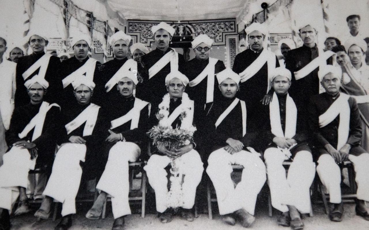Vintage group photo of the first Sidlaghatta Municipal Council members in formal attire with ceremonial sashes, B. Virupakshappa seated at the centre with a garland