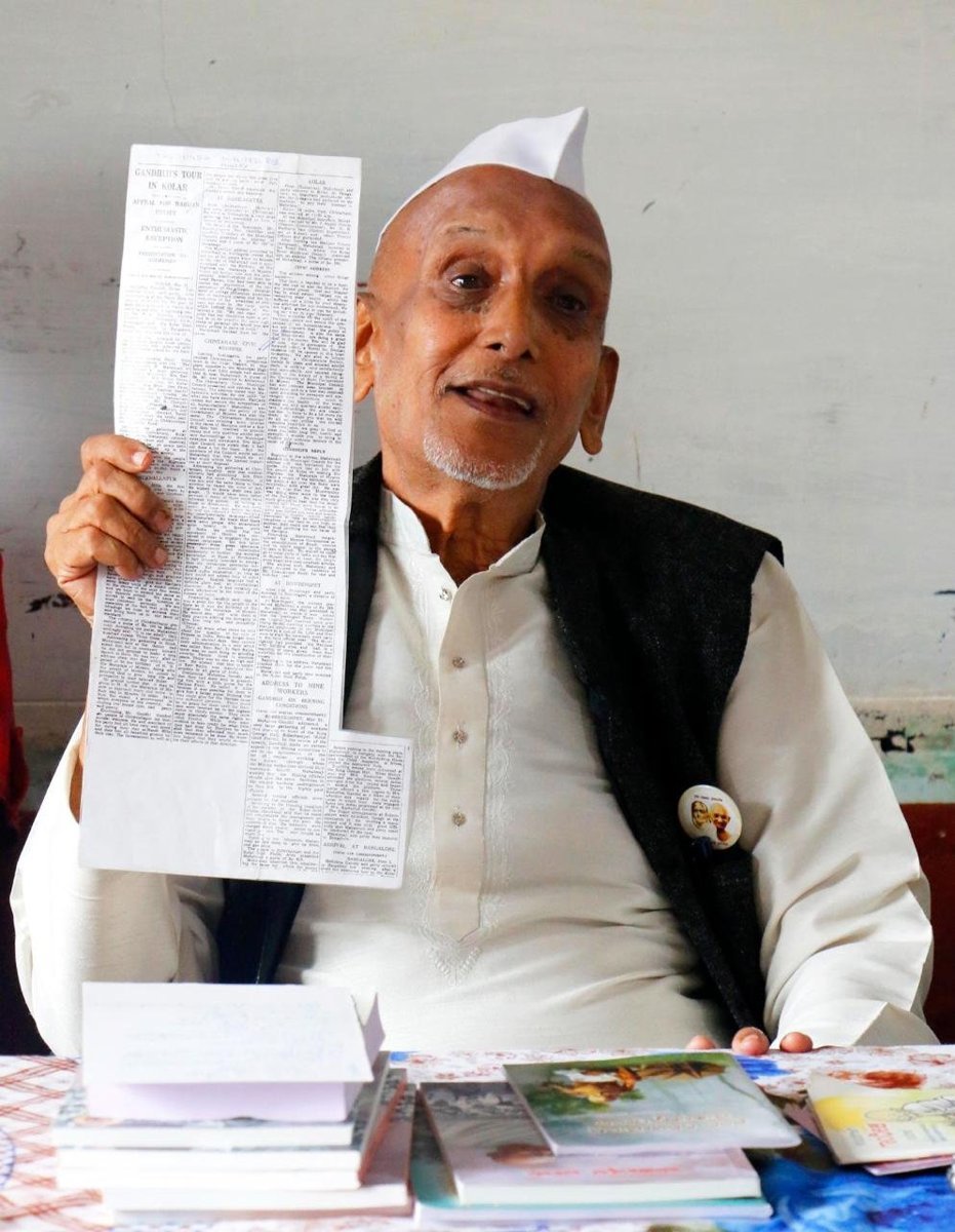 Gandhian Vemagal Somashekar holding a 1936 newspaper reporting Gandhiji tour of Kolar district
